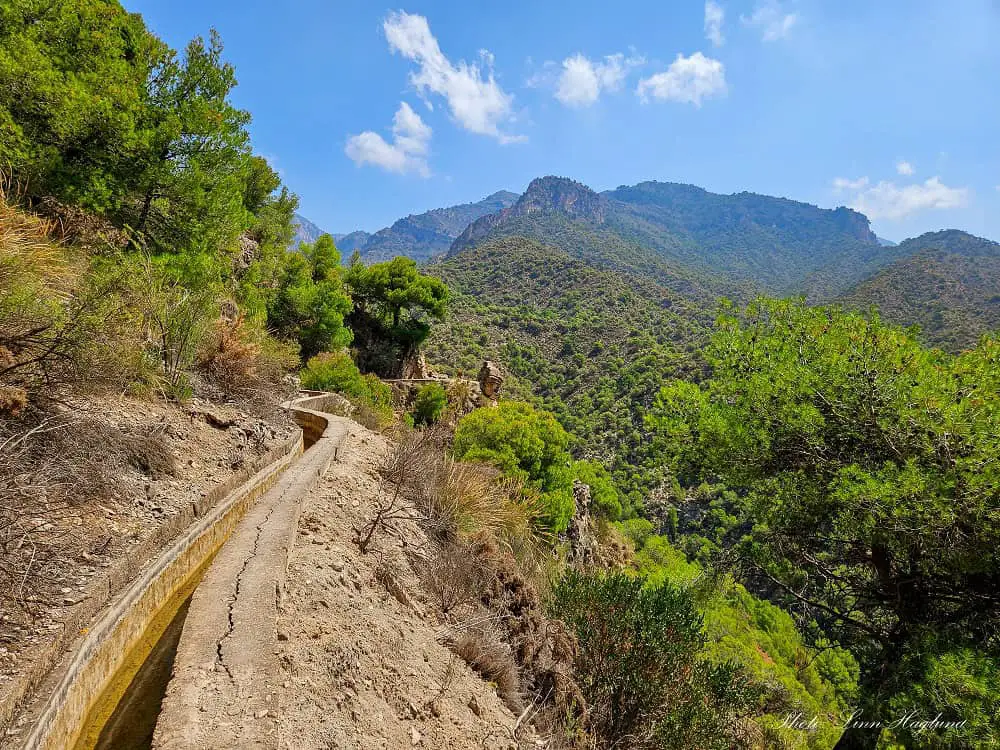 Acequia del Lizar trail Frigiliana Nerja, steeped on the hillside with views of the green canopies of the pinetrees covering the hills around.