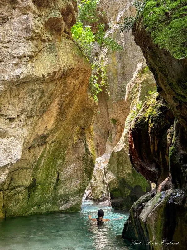 Me swimming in Arroyo Bocaleones Sierra de Grazalema with steep canyon walls on both sides of the narrow river.