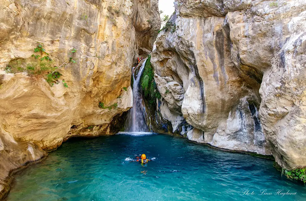 Hike Rio Verde Otivar Granada Spain. People canyoning down a waterfall.