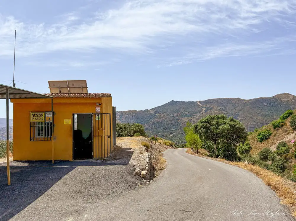 The yellow ticket booth at the entry of the road leading to Rio Verde hike in Otívar.